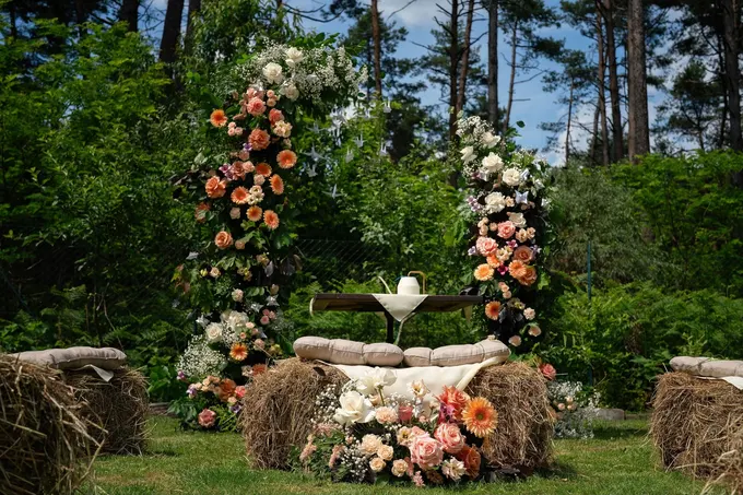 Arco di fiori rosa e arancioni per una cerimonia all’aperto